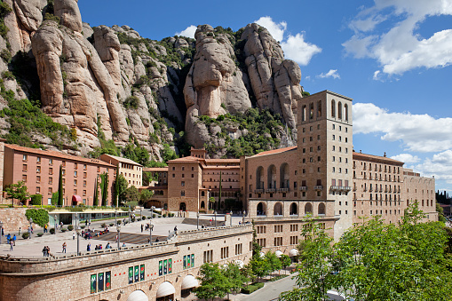 Catalonia, Spain - May 23, 2019: Santa Maria de Montserrat monastery and mountains, famous pilgrimage site.