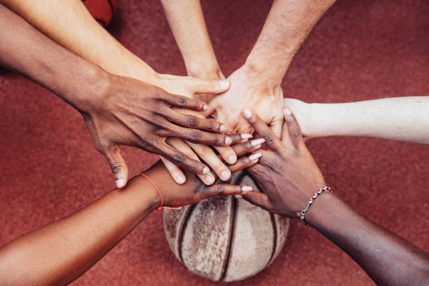 istock Basketball team stacking hands in the court 1170096973