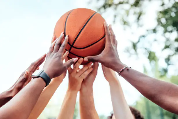 Photo of Multi-ethnic friends holding basketball