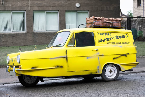 auto a tre ruote gialla robin d'epoca sulla replica della tenuta del consiglio di soli sciocchi e cavalli veicolo del programma tv - serie televisiva foto e immagini stock