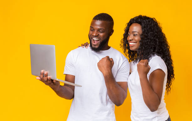 istock Happy black couple celebrating success with laptop 1170099457