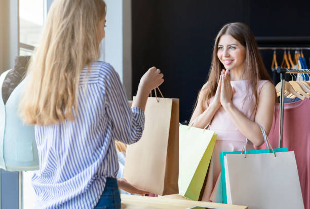 istock Glad customer looking at gift offering by helpful shop assistant 1170099582