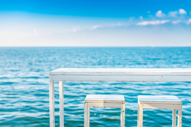 White table and chairs against the blue lake. Located in Erhai Lake, Dali, Yunnan, China.
