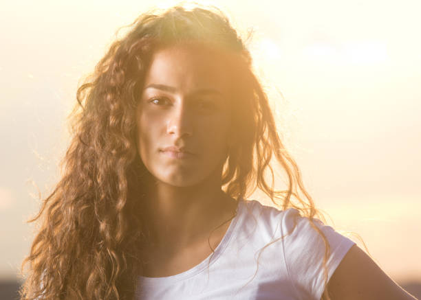 Curly serious woman on sunset