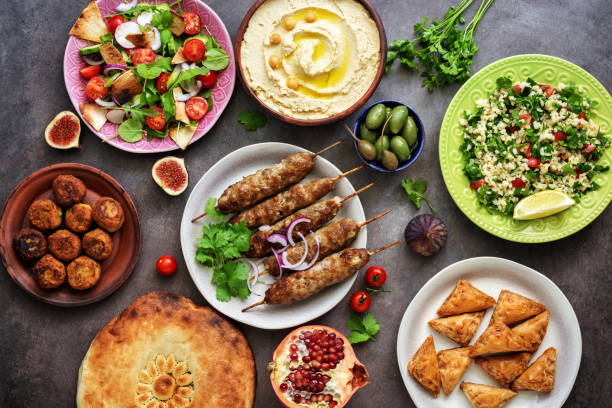 istock Assorted variety of Arabic and Middle Eastern food on a dark rustic background. Hummus,tabbouleh salad, salad Fattoush,pita,meat kebab,falafel,baklava. Set of Arabian dishes.Top view. 1170104556