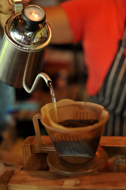 istock Hand drip coffee brewing, filtered coffee pouring water over the coffee powder - Image 1170105016