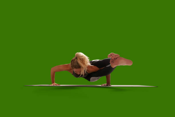 Young sport woman yoga trainer is making stretching nice position outdoors in spring park, so relaxed and healthy, wearing modern pink and black sport outfit