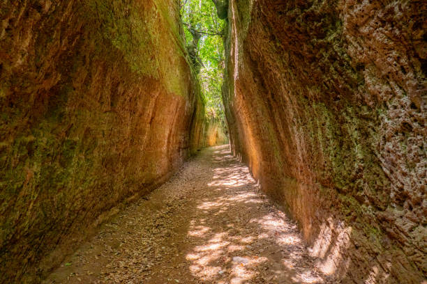 Wonderful Vie Cave, path excavated in tuff rock by etreuscan civilization to link little city of Pitigliano and Sorano, Tuscany, Italy Unbelievable and beautiful Vie Cave are trails excavated thousands years ago by etruscan people in Tuscany, Italy, to link little villages of Sorano, Pitigliano, Sovana. pitigliano stock pictures, royalty-free photos & images