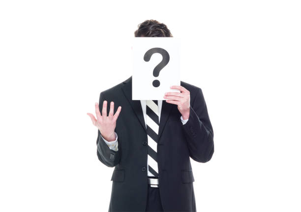 istock Handsome businessman wearing a black suit - is hiding behind a question mark sign 1170111694