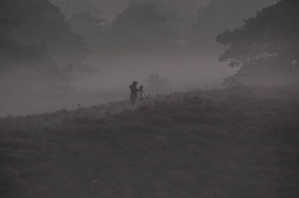 Silhouette of photographer taking photos on the mountains. Filter effect style