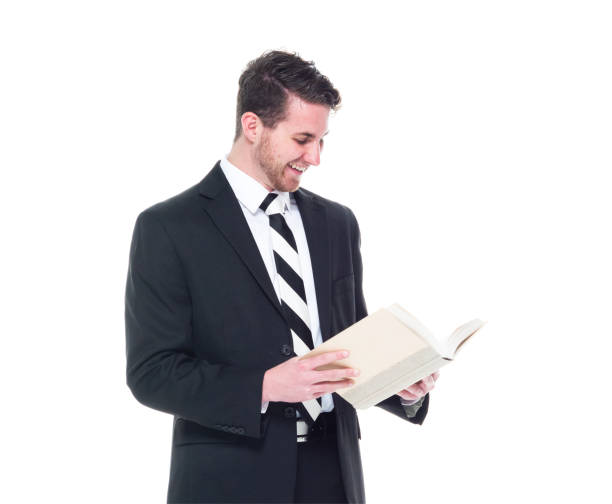 istock Good looking young businessman wearing black suit - holding book 1170112956