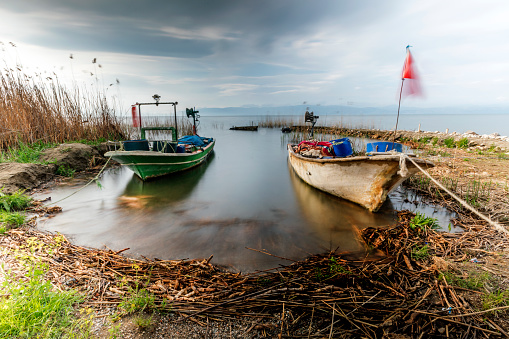 Long exposure landscape of Lake Iznik (Turkish: Iznik Golu) and fishing boats in Bursa, Turkey. In Greek mythology during the Trojan War the region by the Lake Iznik was held by the Phrygians, who sent troops to the aid of King Priam.