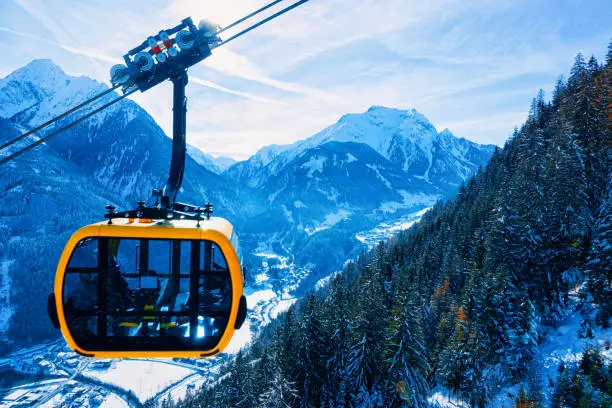 Cable car in Penken park ski resort at Tyrol in Mayrhofen in Zillertal valley, Austria in winter Alps. Chair lifts in Alpine mountains with white snow, blue sky. Downhill fun at Austrian snowy slopes