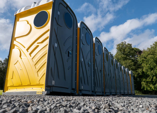 The front of a row of grey and yellow portable chemical toilets The front of a row of grey and yellow portable chemical toilets, being used at an outdoor event. They are located on a gravel area, ready for use. Note the pattern on the sides of each toilet door and on the sides. portable toilet stock pictures, royalty-free photos & images