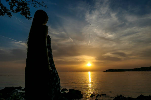 istock Vrsar - A girl enjoying the sunset by the beach 1170124637
