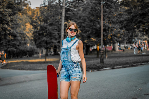 Attractive Female Skateboarder is Having a Fun  Beautiful Young Woman is Enjoying in Spring Day and is Driving Longboard in the Street.