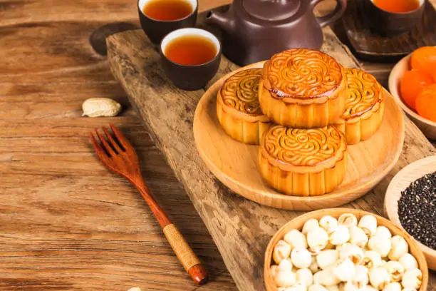 Photo of Traditional mooncakes on table setting with teacup.