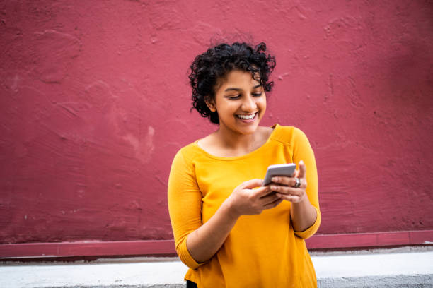 Smiling Indian woman using mobile phone