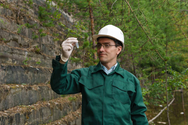 industrial ecologist takes a sample of water from old quarry - impurities imagens e fotografias de stock