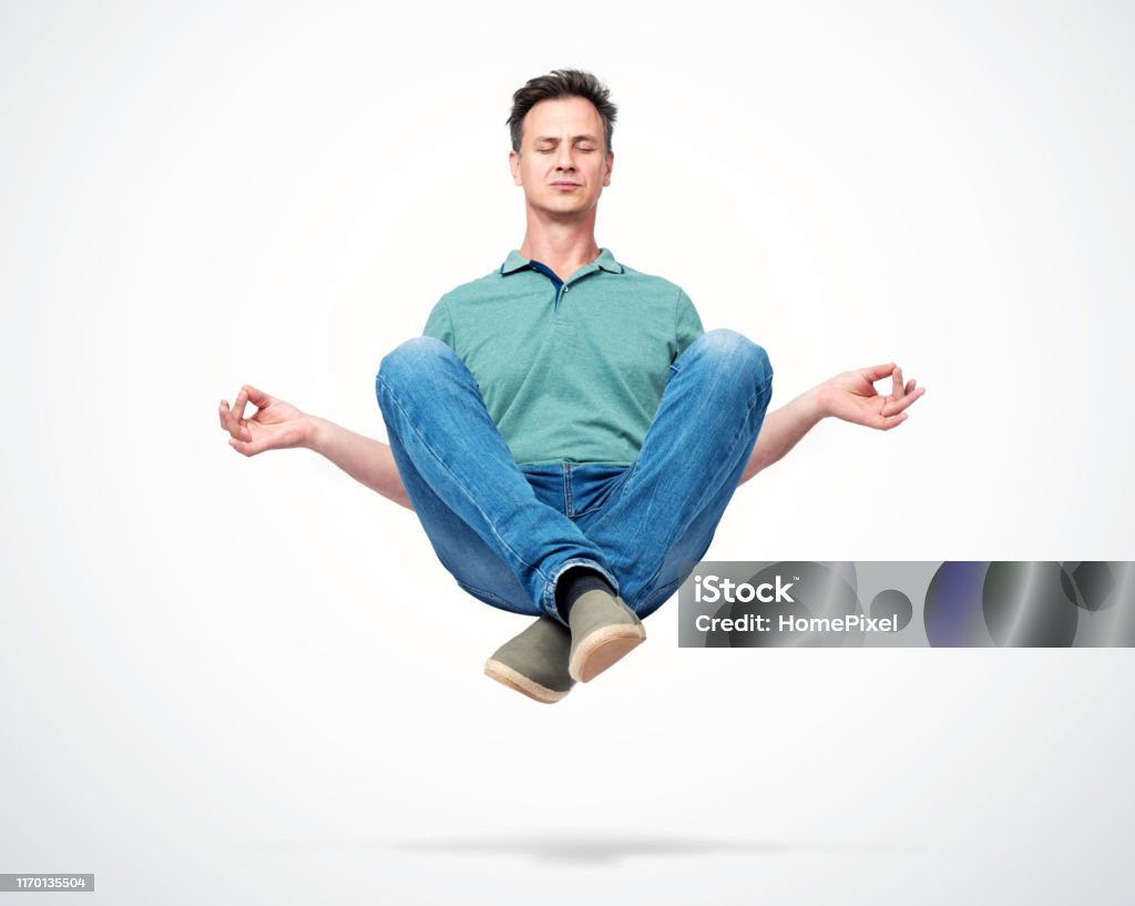 Happy man in casual clothes closing his eyes meditating levitating in the air. Comprehended relaxation Men Stock Photo