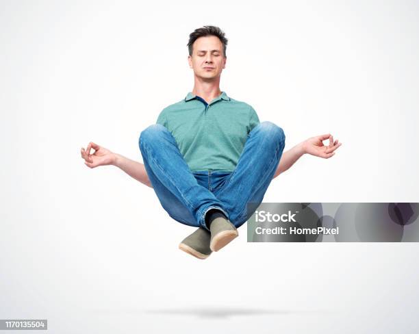 Happy Man In Casual Clothes Closing His Eyes Meditating Levitating In The Air Comprehended Relaxation Stock Photo - Download Image Now