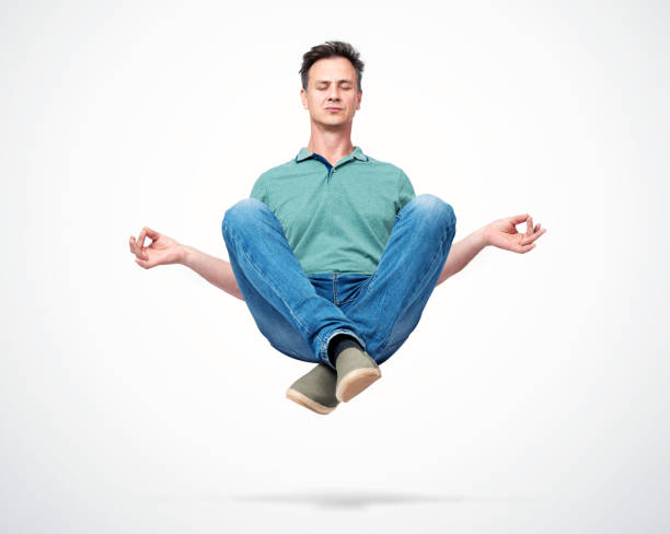 happy man in casual clothes closing his eyes meditating levitating in the air. comprehended relaxation - om symbol fotos imagens e fotografias de stock