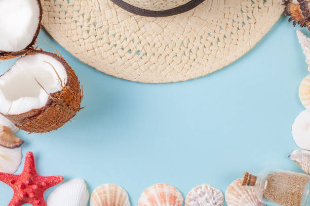 istock Flat lay composition with beautiful starfishes, sea shells, coconut, bottle with sand and straw hat on a blue background 1170137406
