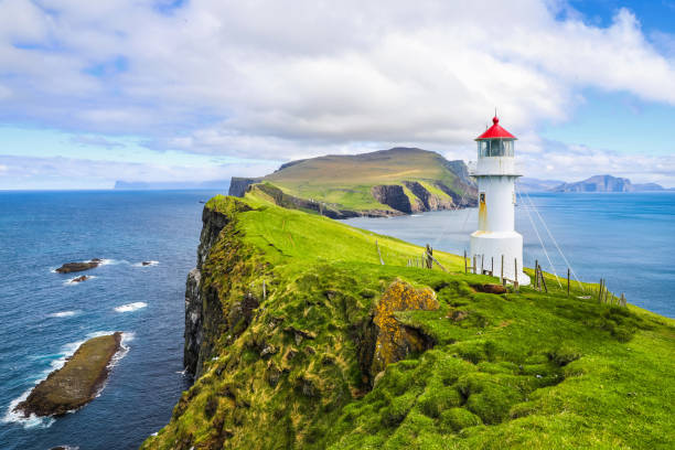 Iconic red and white lighthouse on Mykines Island Iconic red and white lighthouse on Mykines Island in the beautiful green Faroe Islands mykines faroe islands photos stock pictures, royalty-free photos & images