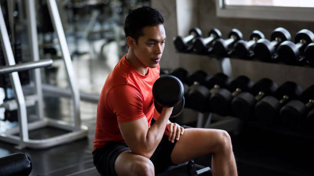 istock Muscle man dumbbell exercise in gym 1170142010