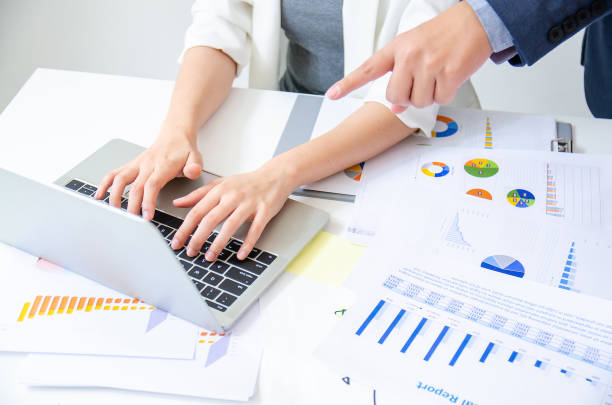 Young male boss commanding his young beautiful worker in work table with graph and chart on office desk.