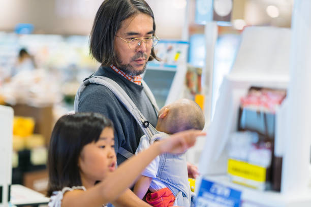 자녀와 함께 슈퍼마켓에서 돈을 지불하는 아버지 - paying children only retail childhood 뉴스 사진 이미지