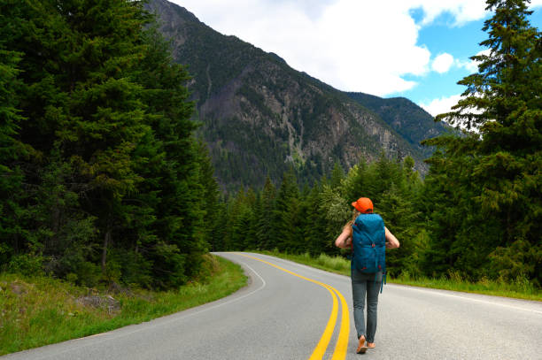 istock Hitchhiker walking on highway against mountain 1170144169
