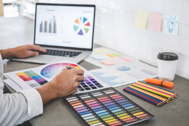 istock Young creative graphic designer working on project architectural drawing and color swatches, selection coloring on graphic chart with work tools and equipment 1170147466