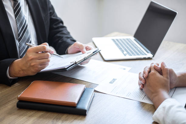istock Employer or committee holding reading a resume with talking during about his profile of candidate, employer in suit is conducting a job interview, manager resource employment and recruitment concept 1170147501