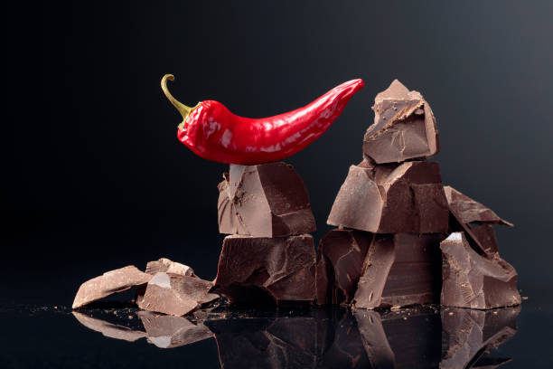 istock Pieces of dark chocolate with red pepper on a dark background. 1170148113