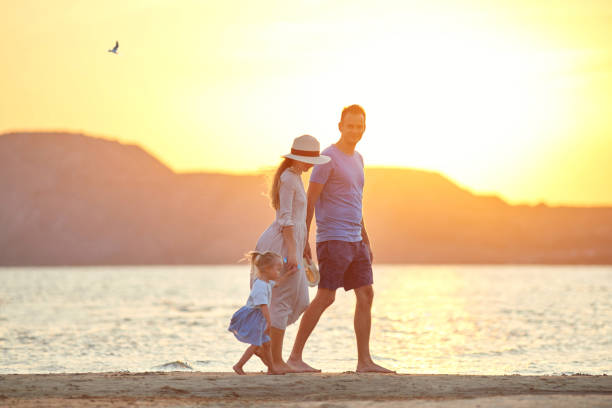 istock family walks at sunset along the beach 1170149314