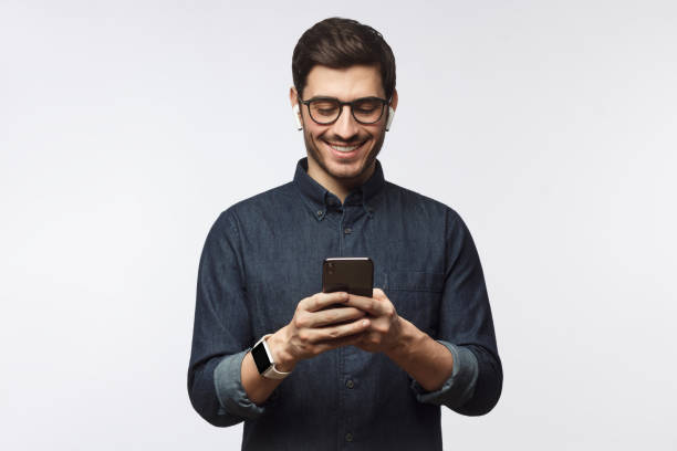 istock Man looking at phone, standing isolated on gray background 1170154534