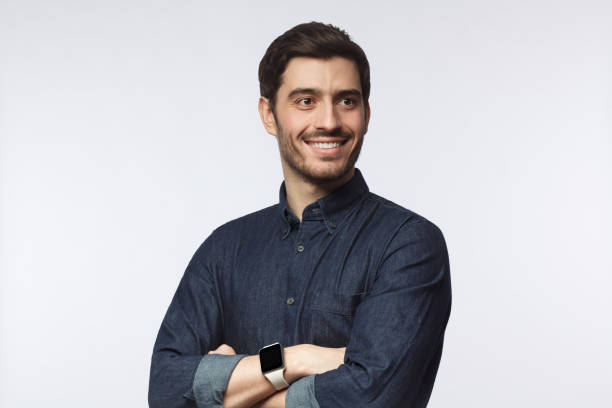 istock Confident man looking away, standing with crossed arms isolated on gray 1170154539