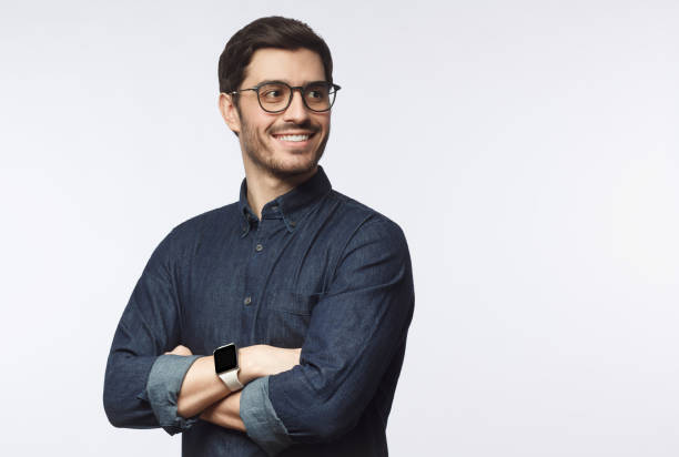 giovane bell'uomo d'affari vestito con camicia casual in denim con smartwatch al polso, isolato su sfondo grigio - one young man only immagine foto e immagini stock