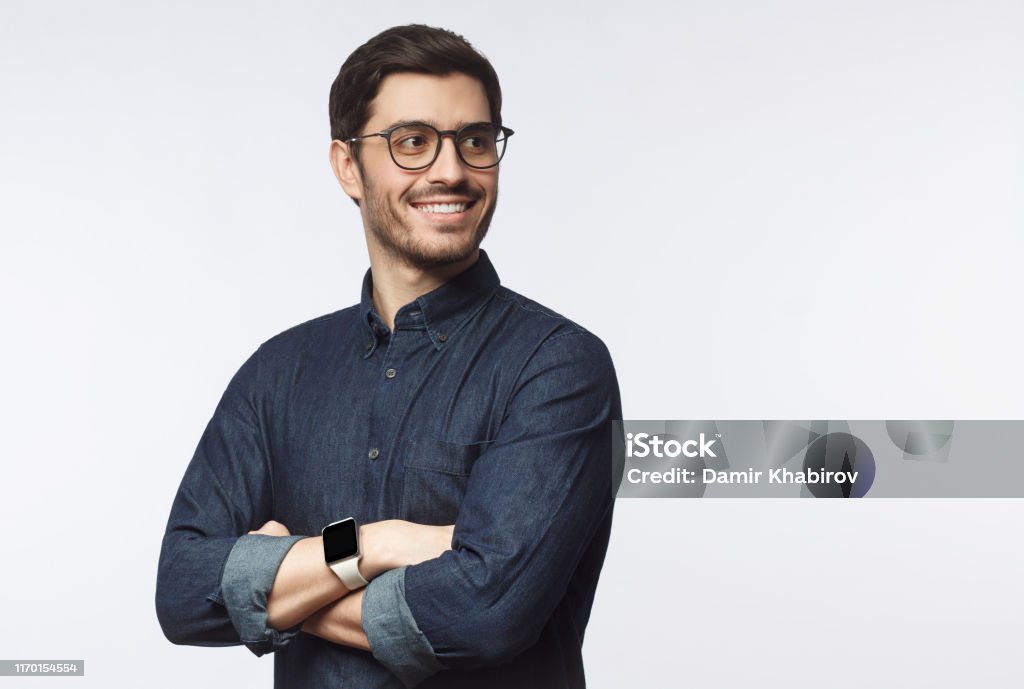 Young handsome business man dressed in casual denim shirt with smartwatch on wrist, isolated on gray background Men Stock Photo