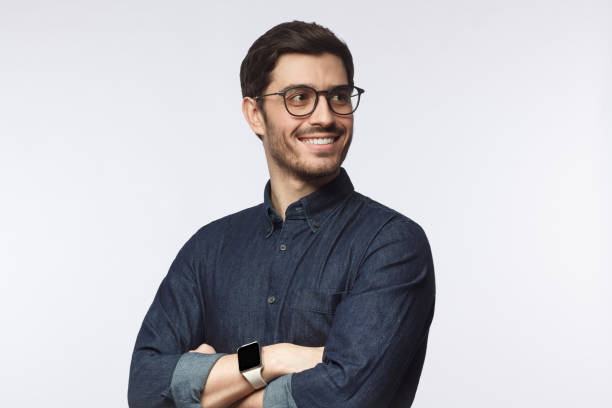 istock Confident young man looking away standing with crossed arms isolated on gray 1170154556