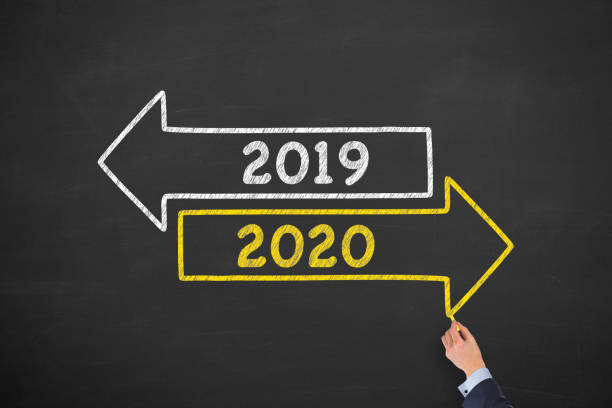 istock Human Hand Drawing Old Year or New Year 2020 on Blackboard Background 1170154625