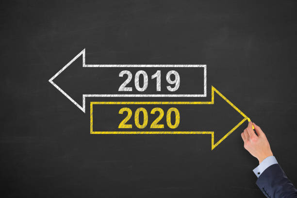 istock Human Hand Drawing Old Year or New Year 2020 on Chalkboard Background 1170154925
