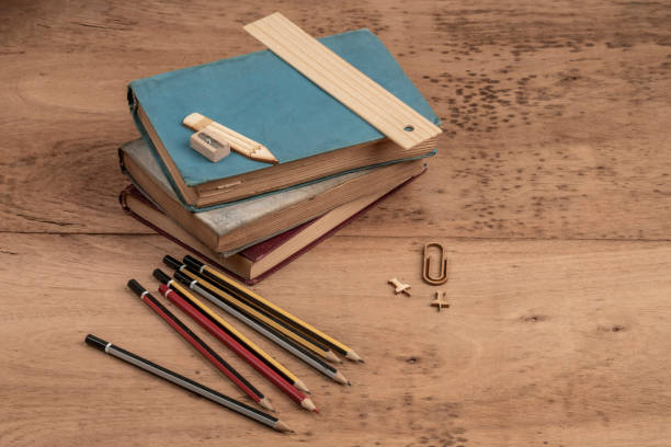 back to school template with book stacks and pencils on a wooden table with copy space