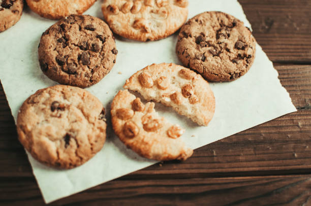 istock Chocolate cookies on parchment paper. Broken biscuits on a wooden table. Selective focus. 1170156357