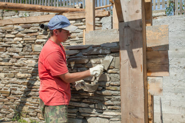 istock man with trowel for stone wall construction. 1170160898