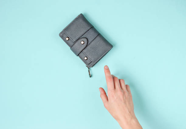 istock Woman's hand takes a leather wallet on blue background. Top view 1170162307