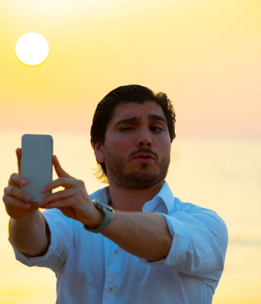 istock Man enjoying colorful sunset or sunrise, taking selfie 1170165412