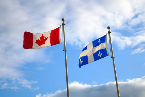 istock Quebec and Canada flags fluttering in the wind together on blue sky 1170165874