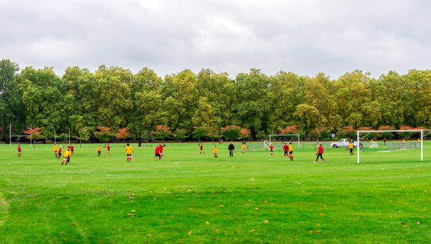 Two junior teams play football in Battersea Park stock photo